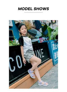 Model wearing purple girls sandals with soft soles and adjustable hook and loop straps.