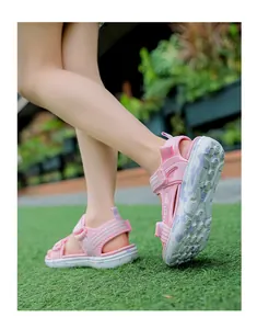 Detailed view of pink girls' beach sandals with comfortable soft soles on grass
