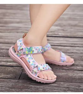 Detailed view of pink girl's sandals with butterfly and checkerboard straps