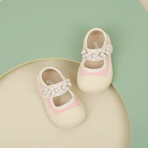 Top view of pink baby girl princess shoes with delicate pearl strap decoration.
