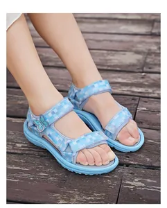 Close-up of girls' blue plaid sandals with butterfly detail on a child's feet