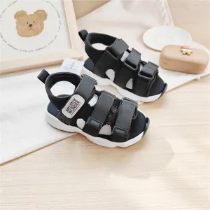 Primo piano di sandali sportivi neri per bambini con triplo velcro e etichetta MLW