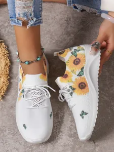 Detailansicht weißer Strick-Sneaker mit leuchtendem Sonnenblumen- und Schmetterlingsdekor