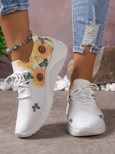 Detailansicht der weißen Mesh-Sneaker mit bunten Sonnenblumen- und Schmetterlingsdrucken.