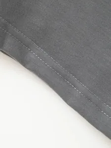 Primer plano detallado de la costura de doble aguja en un polo de algodón gris para hombre