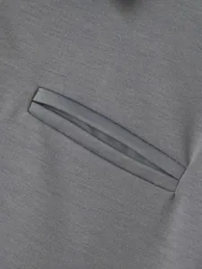 Primer plano de un polo gris para hombre que muestra el detalle del bolsillo en la manga
