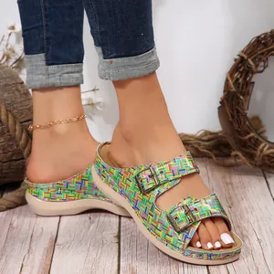 Close-up of colorful woven slides with double metal buckles and comfortable wedge sole.