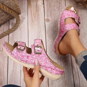 Detail view of pink woven slide sandals featuring double metal buckles and comfortable wedge sole.