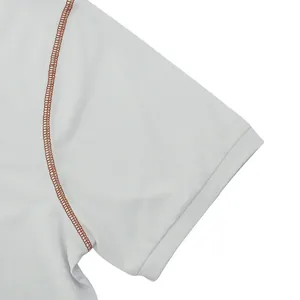 Close-up detail of white quick-dry Polo shirt featuring contrast orange stitching