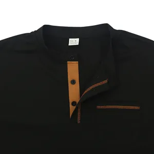 Close-up detail of a men's black polo shirt featuring buttoned neckline and chest pocket