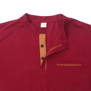 Close-up detail shot of burgundy men's polo shirt featuring a contrast placket and pocket