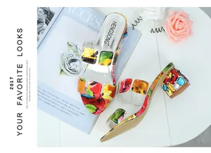 Primo piano dei cinturini a fiori e dei tacchi grossi con strass sui sandali moda