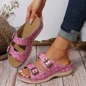 Close-up of pink grid patterned platform sandals featuring adjustable double metal buckles.
