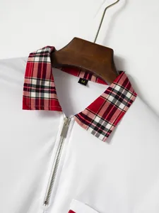 Nahaufnahme eines weißen Poloshirts mit rotem Karokragen und Reißverschluss-Detail.