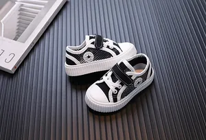 Detailed view of breathable mesh children's sneakers with black and white design