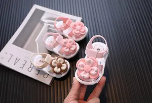 Close-up of pink toddler girl sandals with a large decorative flower and rhinestone details.