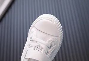 Close-up of white toddler mesh shoes with breathable texture and protective toe cap