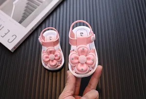 Close-up view of pink toddler walking sandals with large decorative flower and rhinestones.