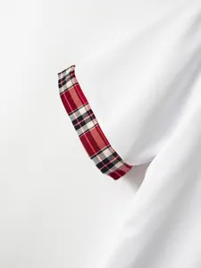 Detailansicht eines weißen Herren-Poloshirts mit karierten Ärmelbündchen und Piqué-Textur