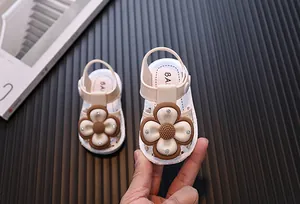 Closed-toe baby girl sandals with large floral embellishment and adjustable heel strap