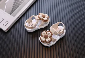 Detailed view of beige baby girl sandals featuring a large brown 3D flower decoration.