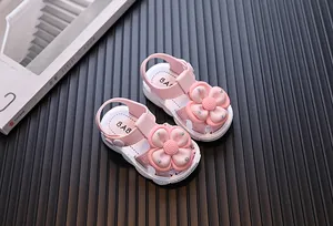 Detailed view of pink toddler girl sandals featuring a decorative flower and closed-toe design