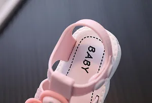 Detail view of pink baby girl sandal heel strap with BABY printed on the soft insole