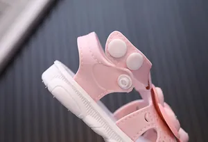 Detail view of pink toddler girl sandals with adjustable heel snap strap.