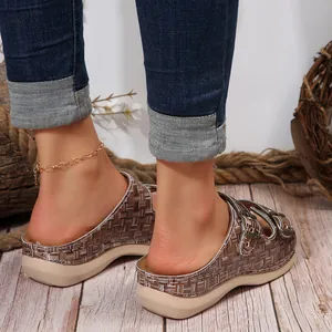 Detail view of women's woven wedge sandals with double metal buckles and platform heel.