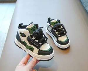 Primer plano de zapatillas altas infantiles con detalles verdes y cordones negros gruesos.