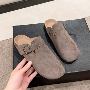 Detail of taupe suede clog slippers with cork sole and adjustable buckle strap