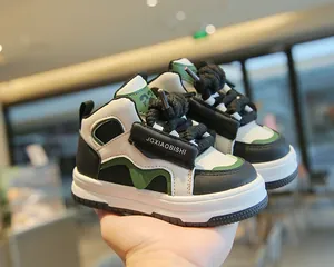 Detalle macro de zapatillas altas para niños en colores negro y verde estilo moderno.