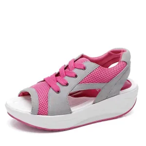 Vista lateral de sandalias con cuña deportivas para mujer en gris y rosa con punta abierta