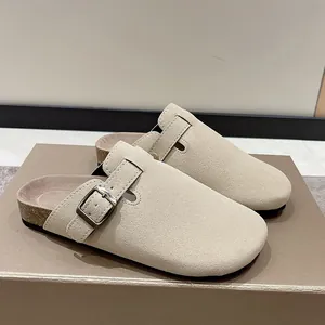 Side view of stylish beige suede clogs featuring cork sole and metallic buckle strap