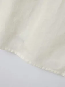 Close-up of white men's casual shirt hem showing neat stitching and cotton fabric texture