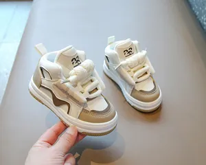 Detalle de cerca de zapatillas altas beige para niños con cordones gruesos de cuerda.