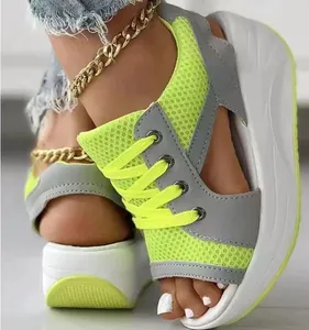 Detalle de sandalias con cuña en punto amarillo neón con cordones y punta abierta