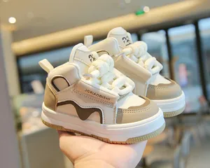 Vista detallada de zapatillas altas para niños en elegantes colores crema y caqui