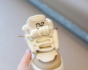 Detalle de zapatillas altas tipo chunky para niños con cordones gruesos de cuerda en crema