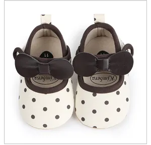 Vue de dessus de chaussures bébé crème à pois marron avec un grand nœud décor