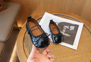 Detail showing glossy black patent leather and bow on girls' princess shoes