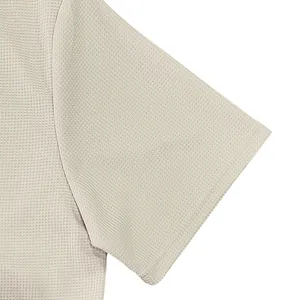 Close-up view of the breathable waffle knit texture on a men's beige short sleeve shirt