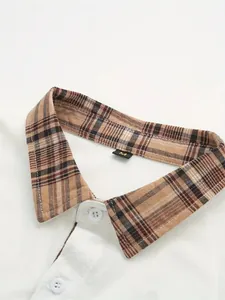 Detalle de camisa casual blanca para hombre con cuello de cuadros marrones y botones.