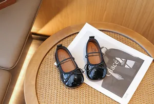 Close-up of black patent leather girls' Mary Jane shoes with delicate bow detail