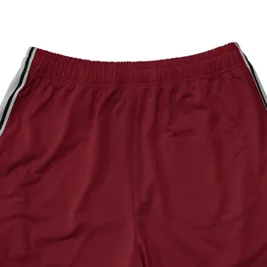 Gedetailleerde weergave van een rode sportbroek met elastische taille en zijstrepen