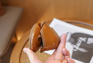 Close-up of flexible soft-soled brown patent leather girl's flats with bow detail