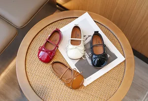 Elegant girls' bow-tie Mary Jane shoes displayed in four classic colors on a wooden table
