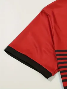 Detail shot of men's red polo shirt featuring black ribbed cuff and striped side panel