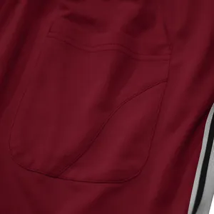 Detailopname van de achterzak op een bordeauxrode sportieve herenjoggingbroek