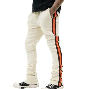 Detail van een slim-fit herensportbroek met opvallende oranje en bruine zijstrepen erop